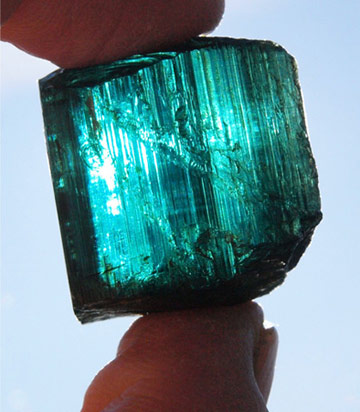 Eureka Blue Maine Tourmaline crystal held up to the sun
